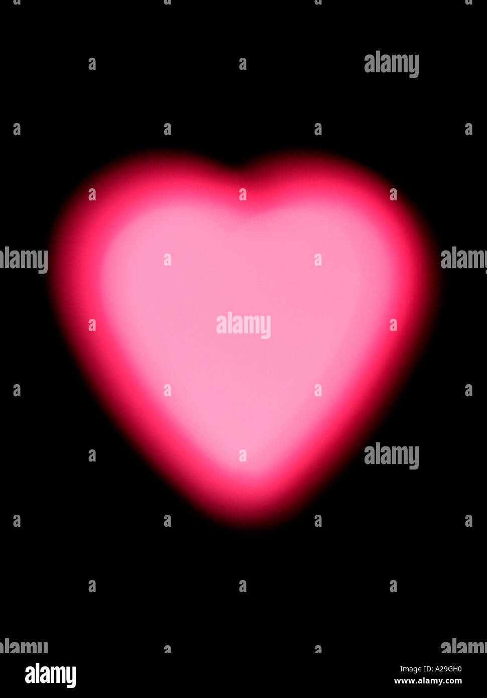 Incandescente cuore rosa su sfondo nero Foto Stock