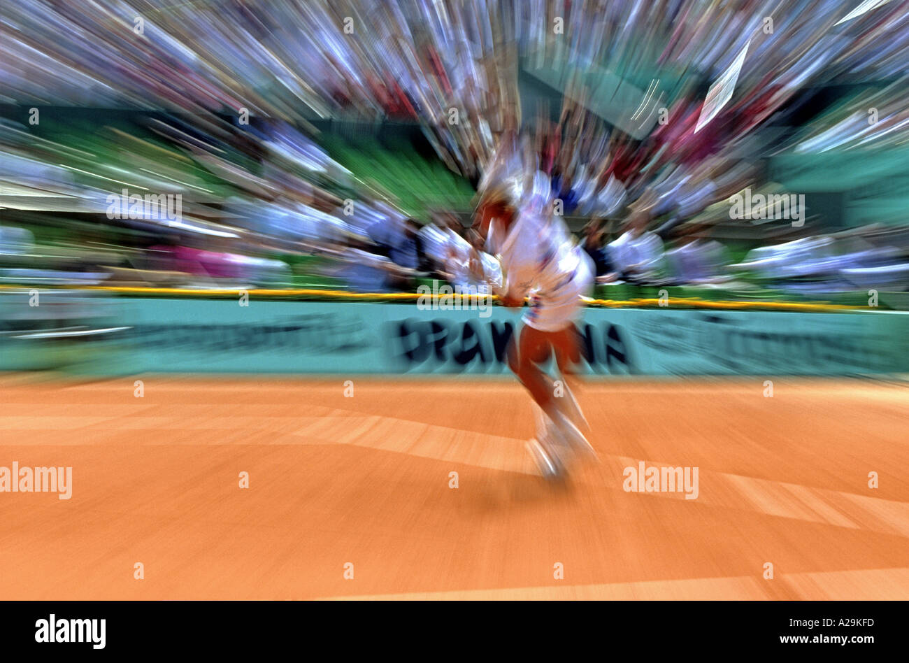 Lo zoom della fotocamera di burst per effetto di un uomo giocando una partita di tennis su terra rossa Foto Stock