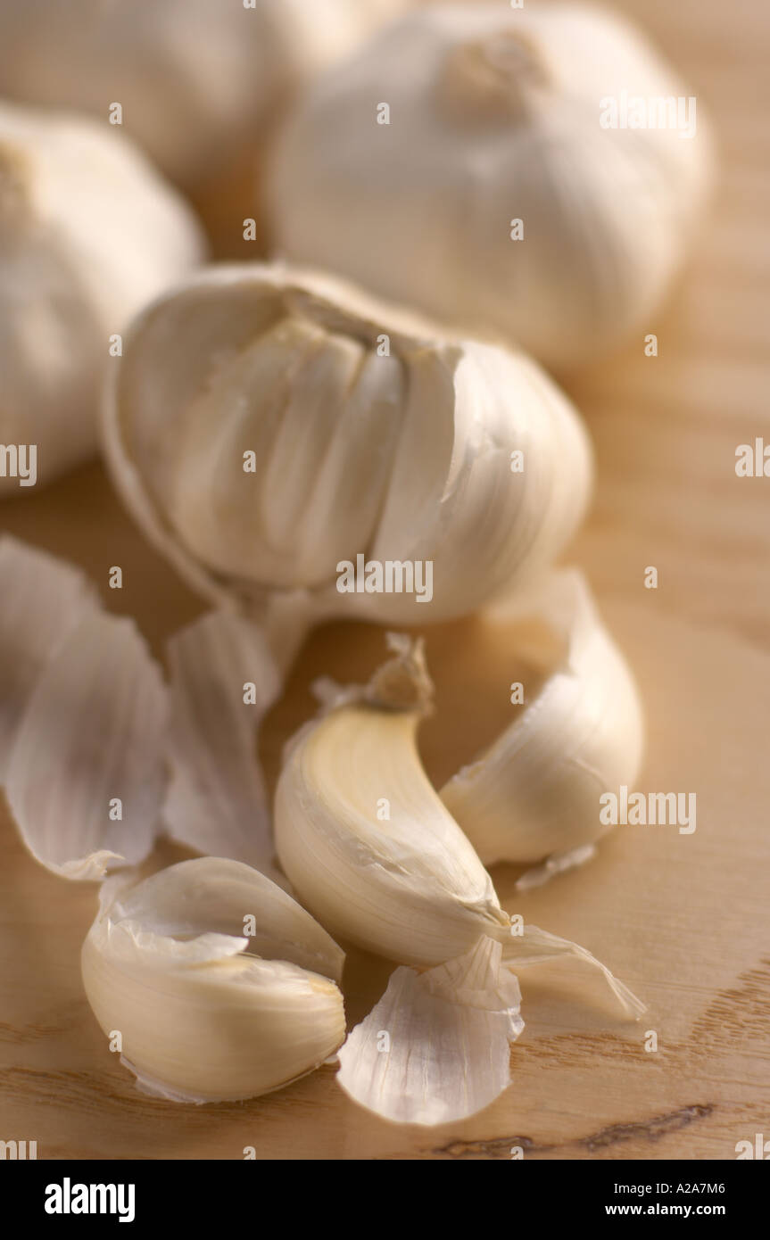spicchi d'aglio su un tavolo di legno con un bulbo rotto aperto Foto Stock