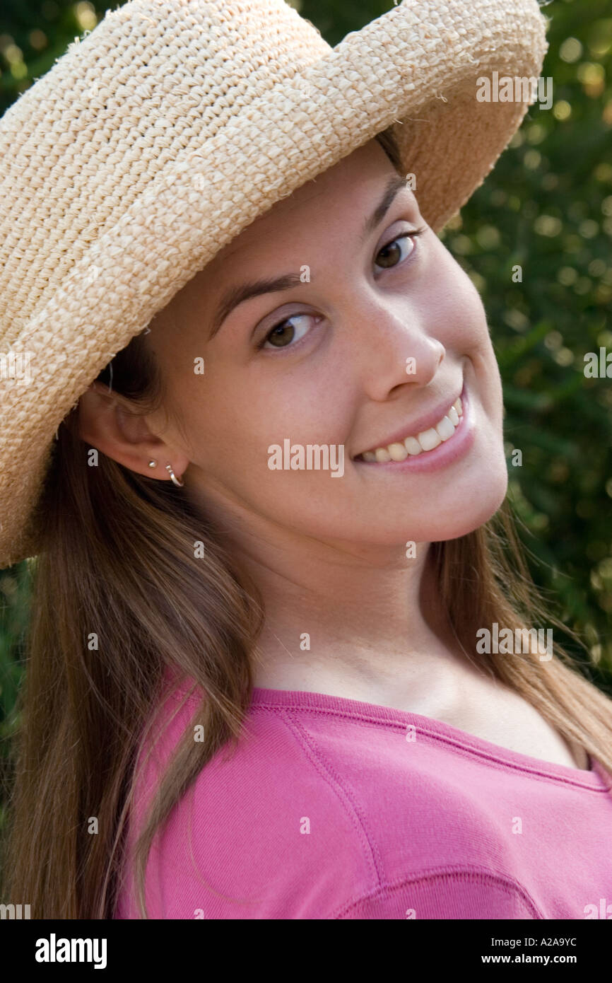 Ritratto di una bella ragazza o un adolescente, sorridente e indossando un cappello di paglia. Foto Stock