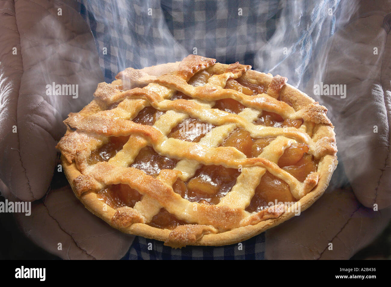 La torta di mele con vapore essendo trattenuto da Baker Foto Stock
