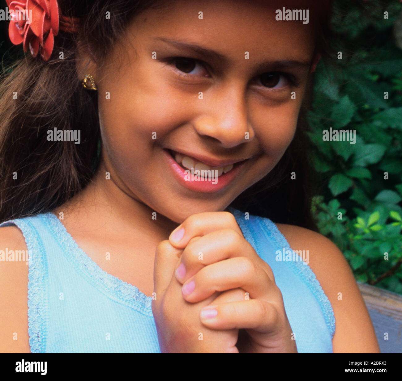 USA il ritratto di nove dieci anni di undici anni ragazza con un fiore rosso tra i capelli Foto Stock