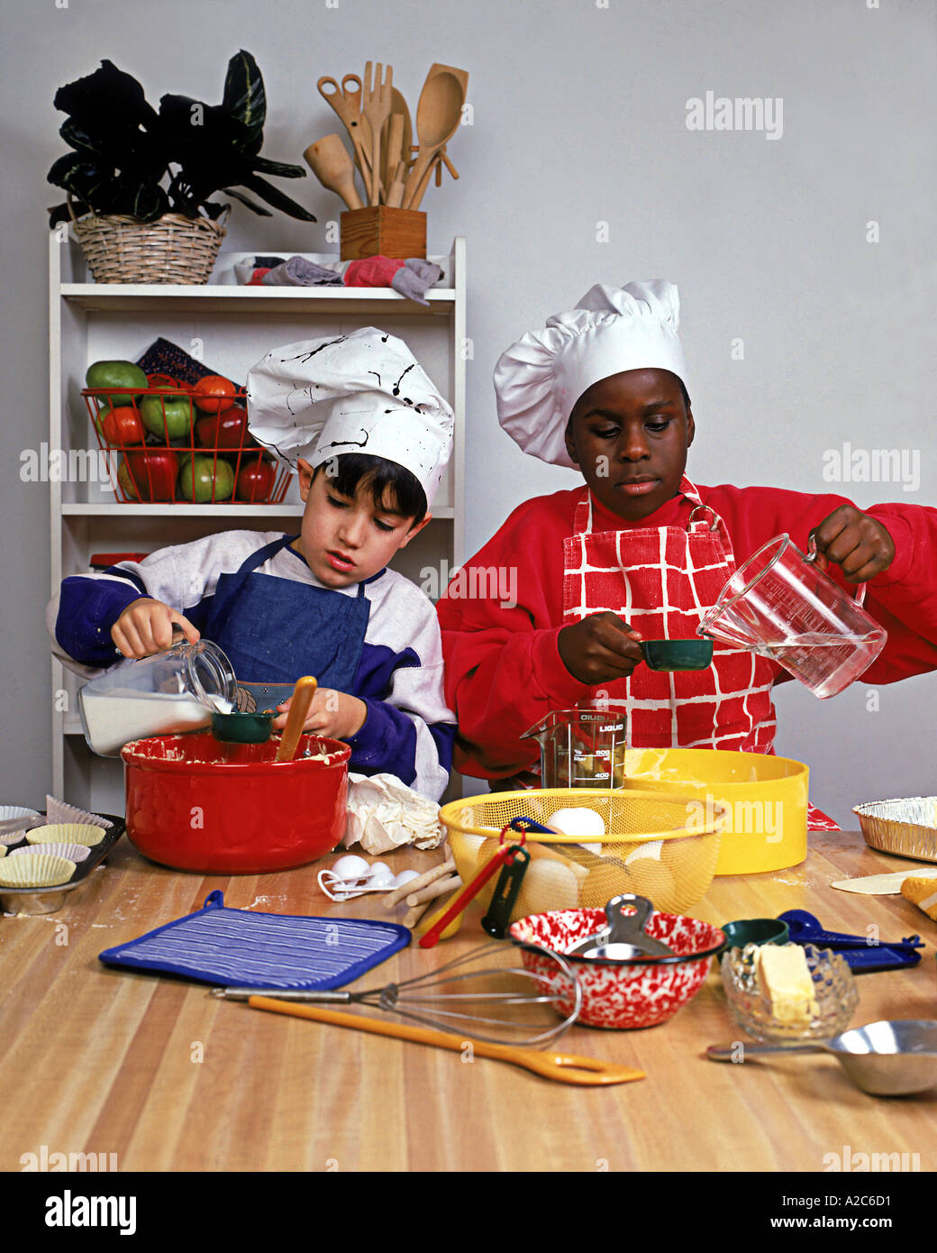 Colpo verticale di due giovani ragazzi giocare chefs preparare il cibo Foto Stock