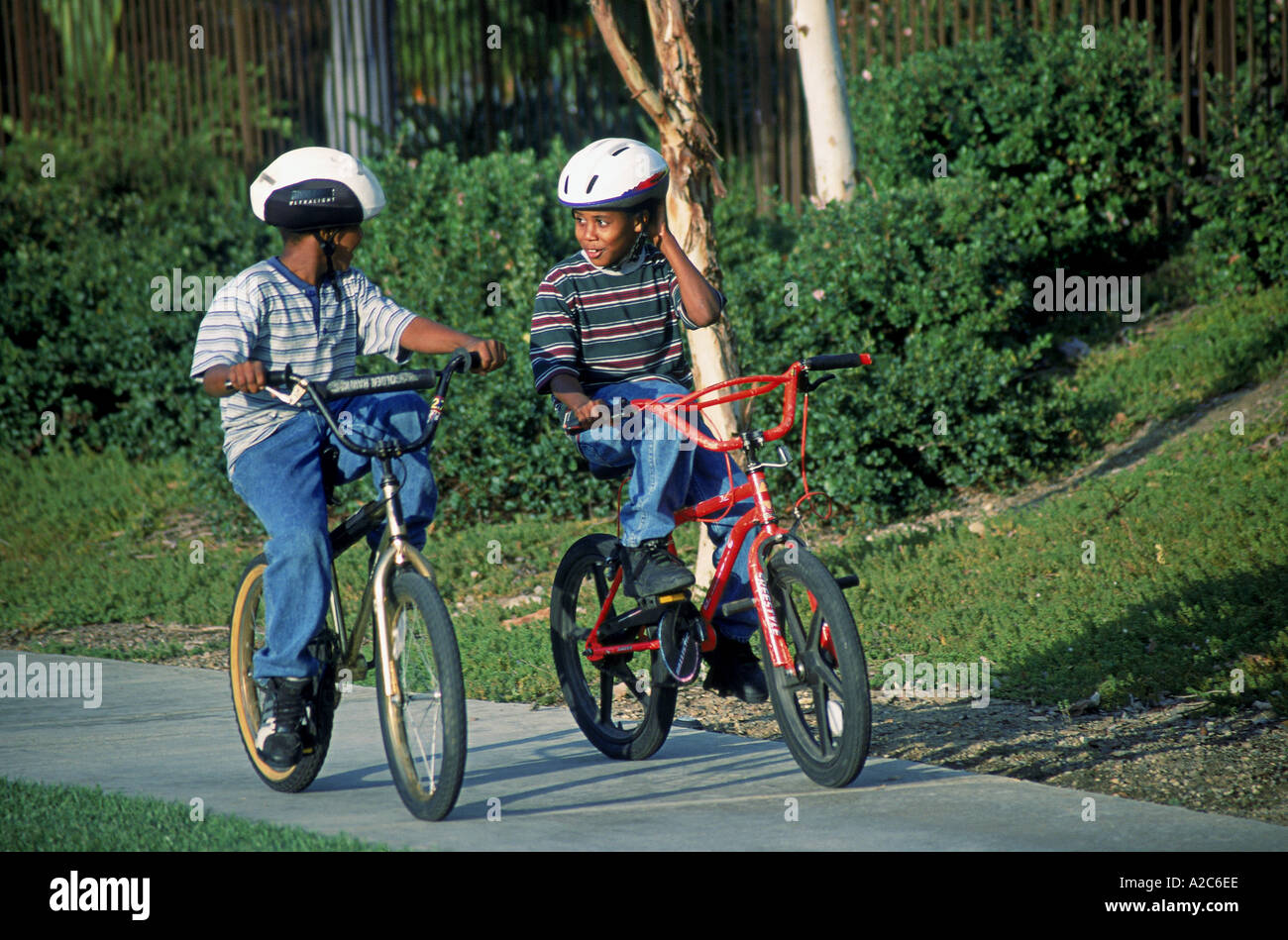 Bambini Bambino bicicletta equitazione biciclette a noleggio multi razziale multiculturale di diversità culturale suburbana due ragazzi 8-10 anni vecchio la sicurezza negli Stati Uniti Foto Stock