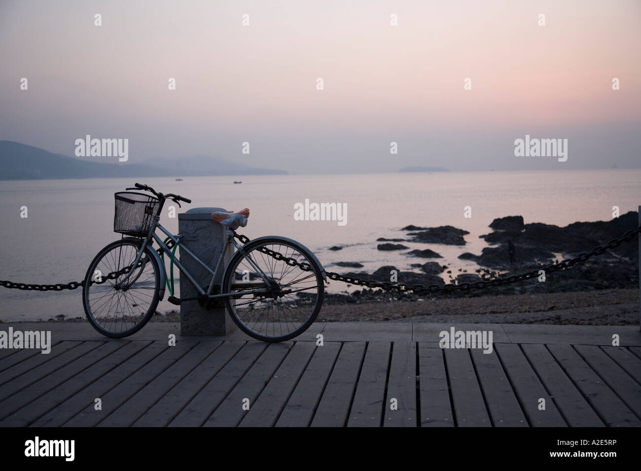 La bicicletta di una arricciatura picker attende il suo proprietario nella città costiera di Dalian nel nord della Cina. Foto Stock
