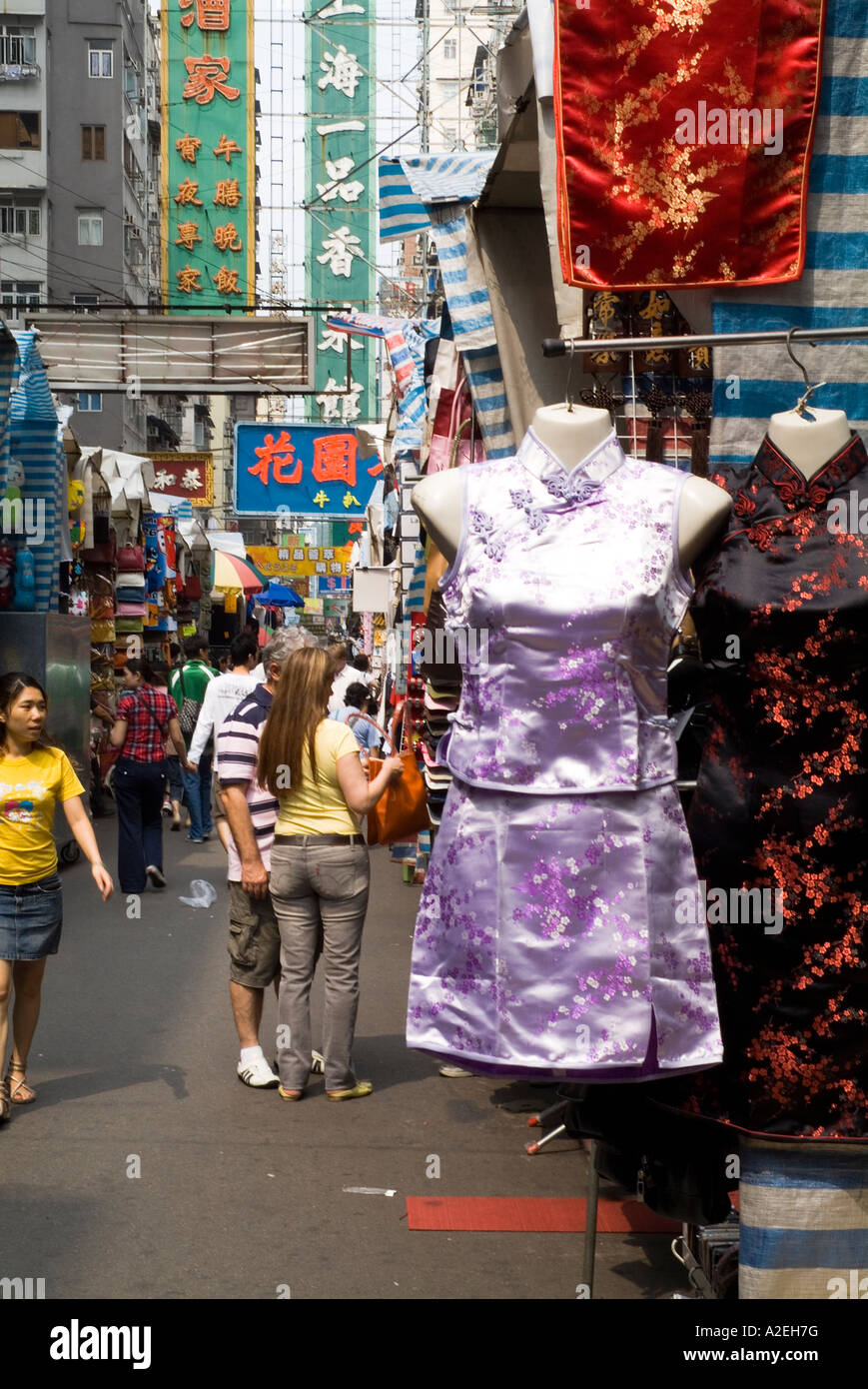 dh Ladies Market MONG KOK HONG KONG Tourist coppia shopping nel mercato di strada cinese seta breve cheongsam vestito tung choi turisti mongkok abbigliamento Foto Stock