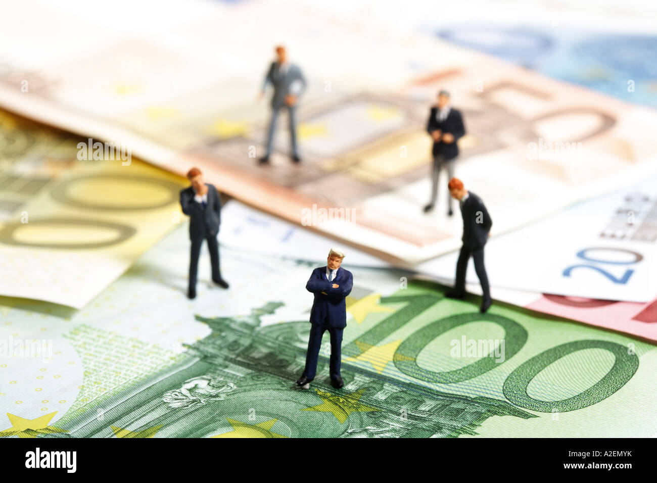 Statuette in piedi sulle banconote in euro Foto Stock
