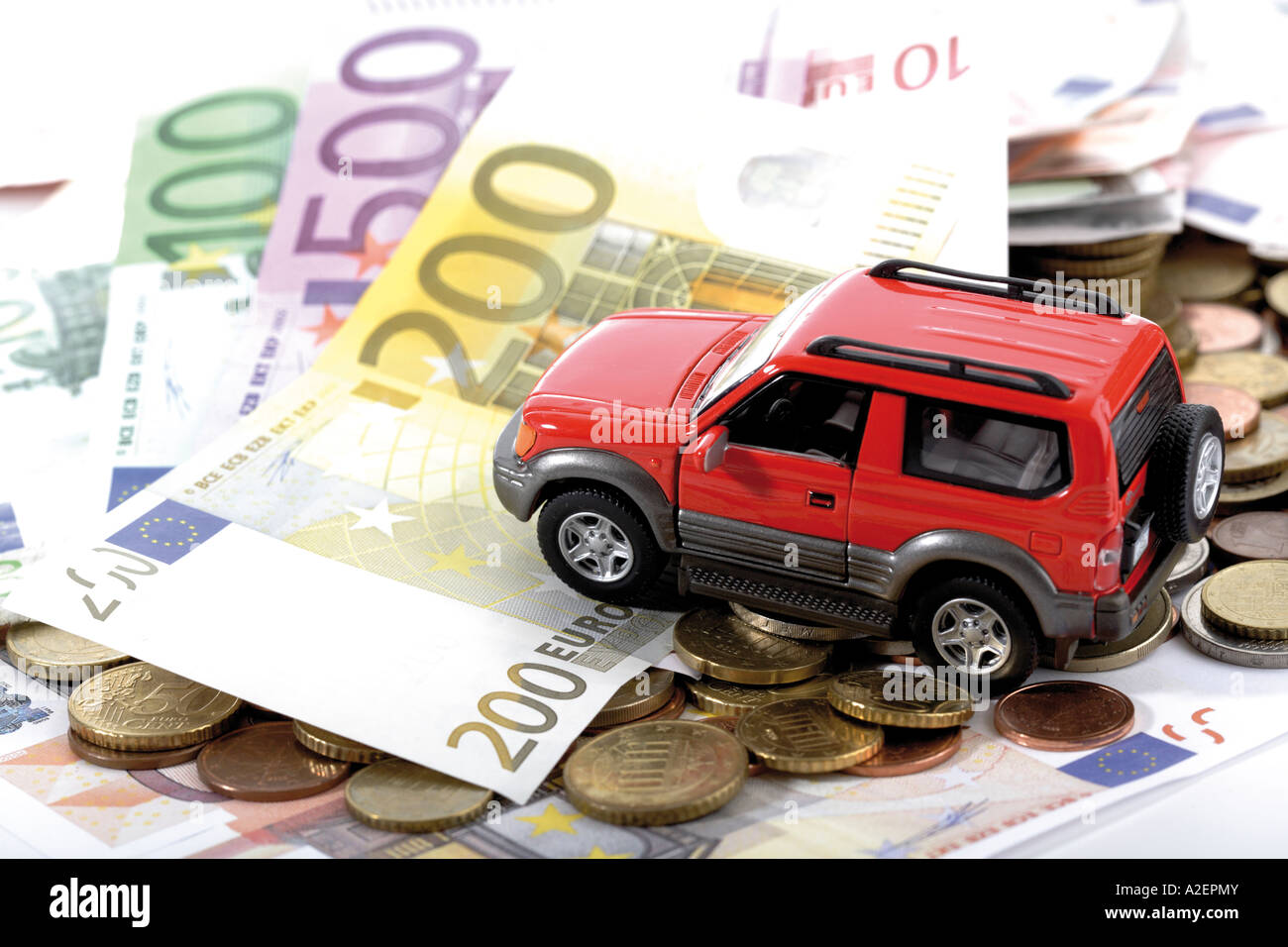 Giocattolo auto sulle banconote e monete in euro Foto Stock