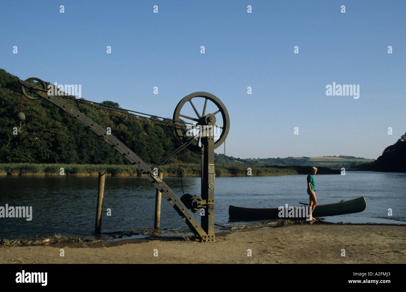 Canoa e vecchia gru vittoriano a Cotehele Quay tasto a Tamar a Cotehele Cornwall Regno Unito Gran Bretagna Foto Stock