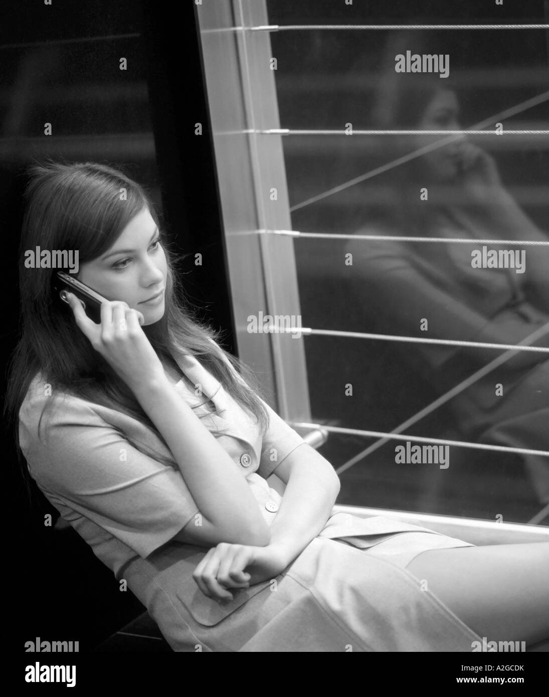 1216380 indoor nel riquadro office riflessione giovane donna 25 30 brunette capelli lunghi sit piano tenere premuto Telefono Telefono cellulare cellulare Foto Stock