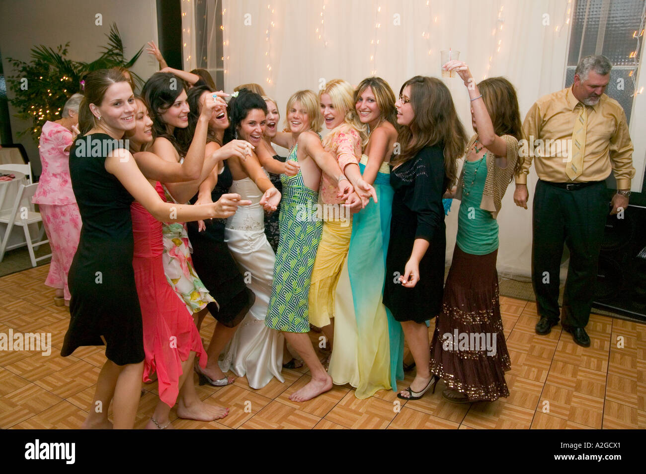 Sposa balli in tra il gruppo di giovani donne al suo ricevimento di nozze in Malibu, California Foto Stock