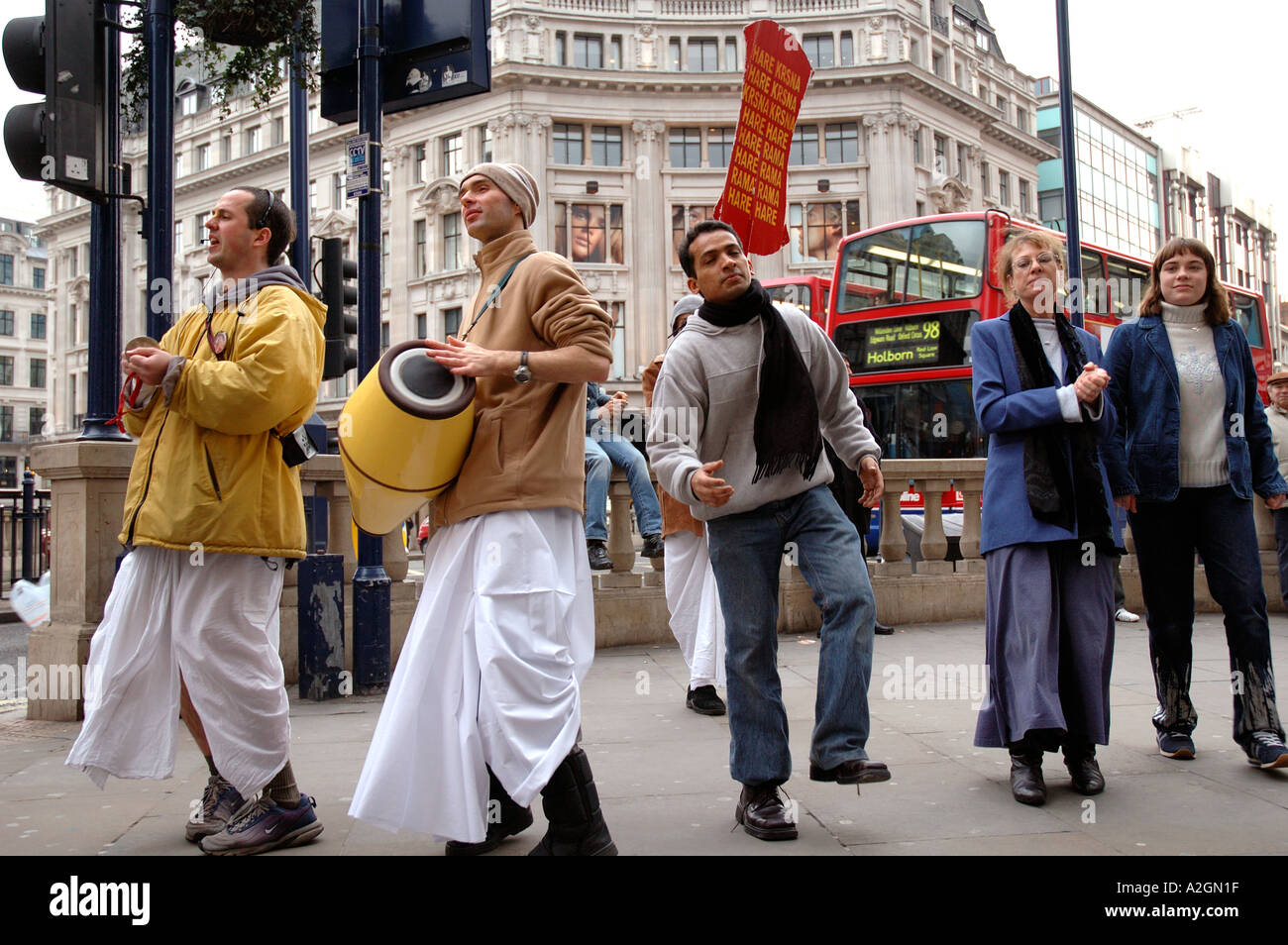 Hare Krishna devoti dancing e il reclutamento di persone in Oxford Street  Londra Centrale Foto stock - Alamy