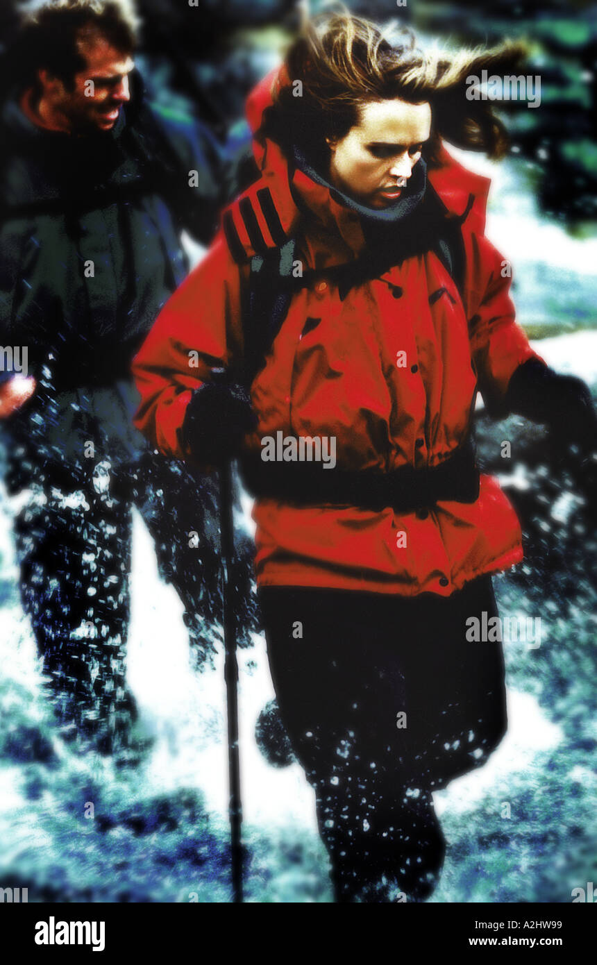 Donna età 20-25 indossando vestiti di alpinismo a piedi attraverso un fiume. Foto Stock