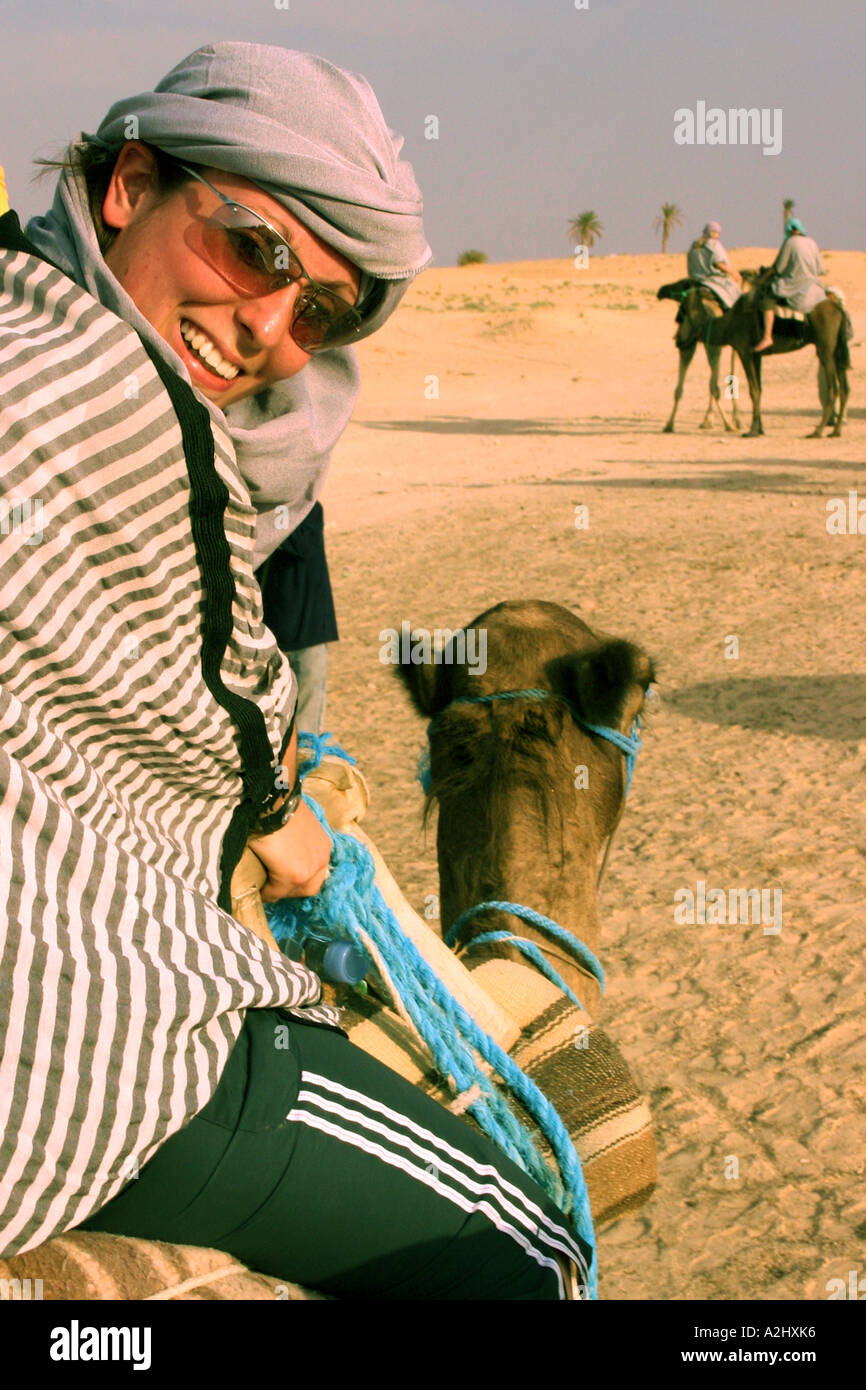 Cammello con femmina in inglese, cavaliere a cavallo attraverso il deserto del Sahara, Tunisia Foto Stock