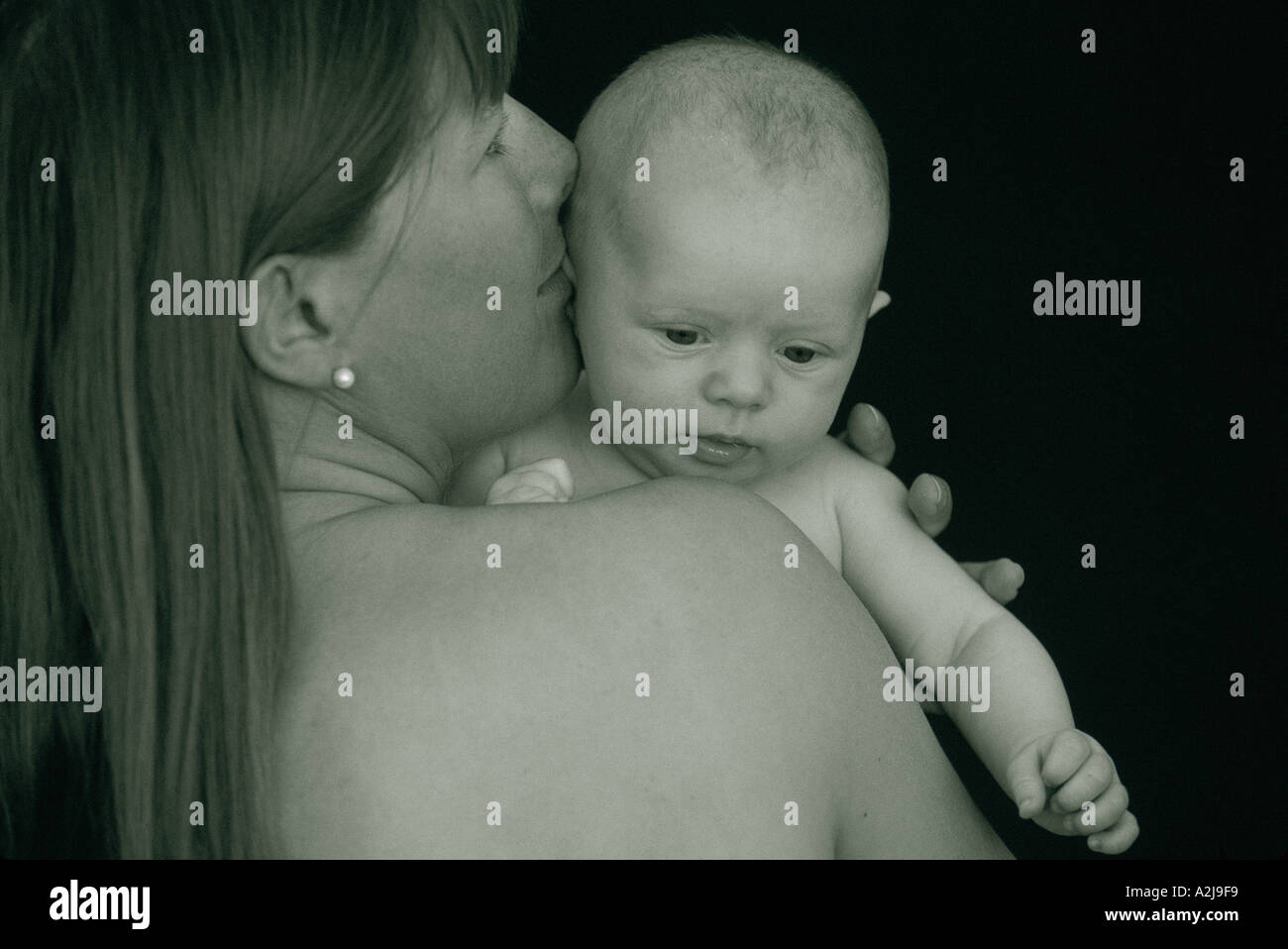 Una madre detiene il suo neonato bambino sulla sua spalla Foto Stock