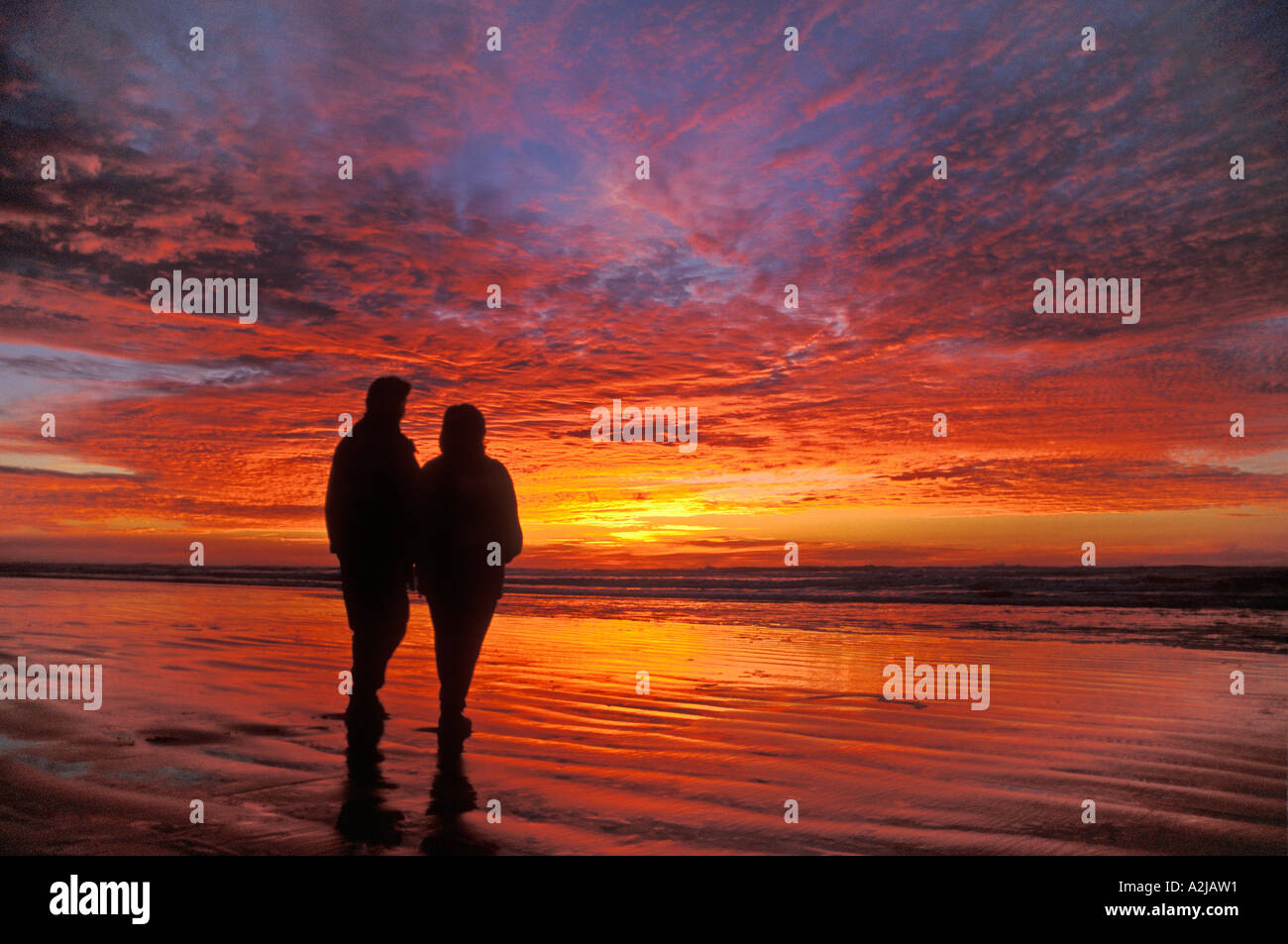 Due donne gli amici a guardare un incredibile tramonto a Nye Beach Newport Oregon Coast Foto Stock