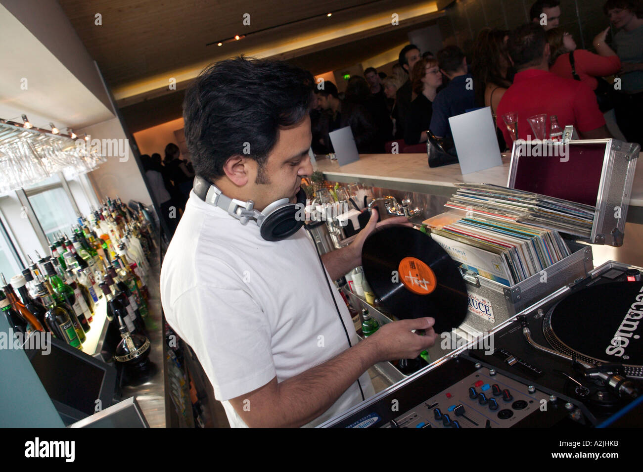 Un DJ in un bar a Birmingham Regno Unito cambia record durante il suo set. Foto Stock