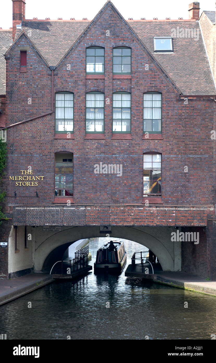 Un canal boat fa il suo modo sotto un ponte nel centro di Birmingham REGNO UNITO Foto Stock