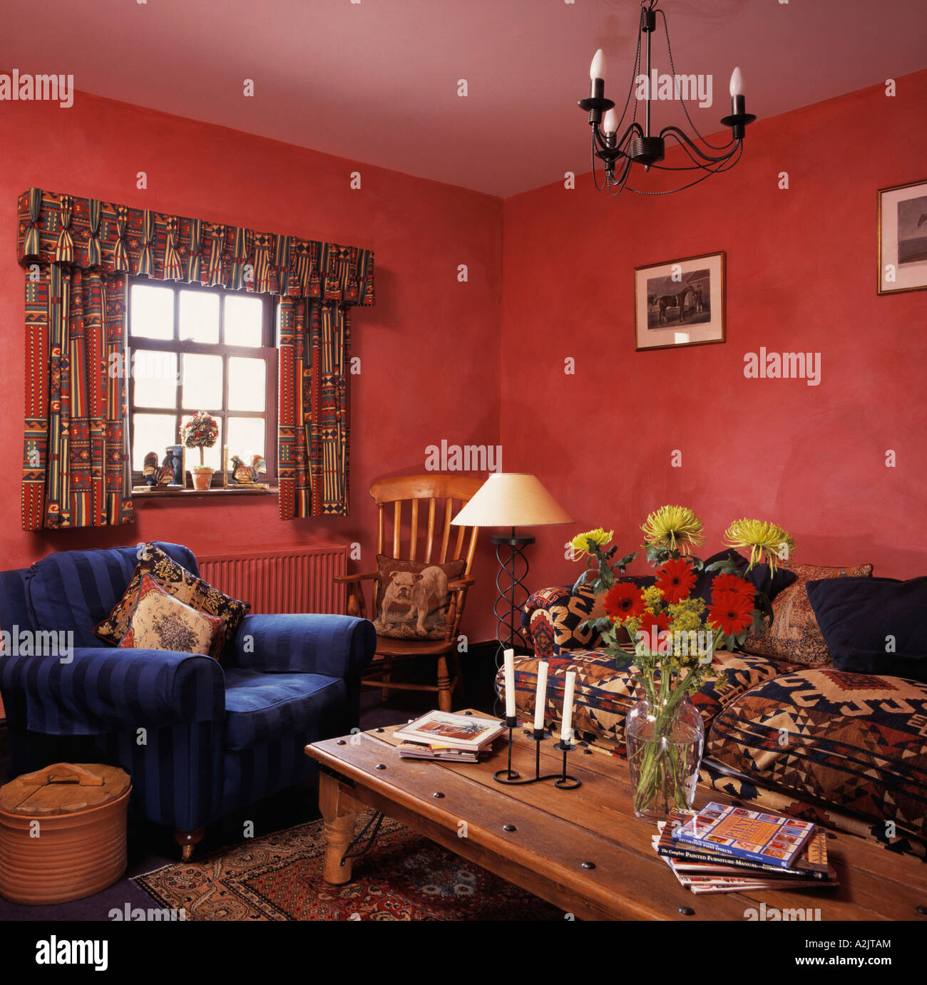 Poltrona blu e caffè in legno-tabella in rosso cottage soggiorno Foto Stock