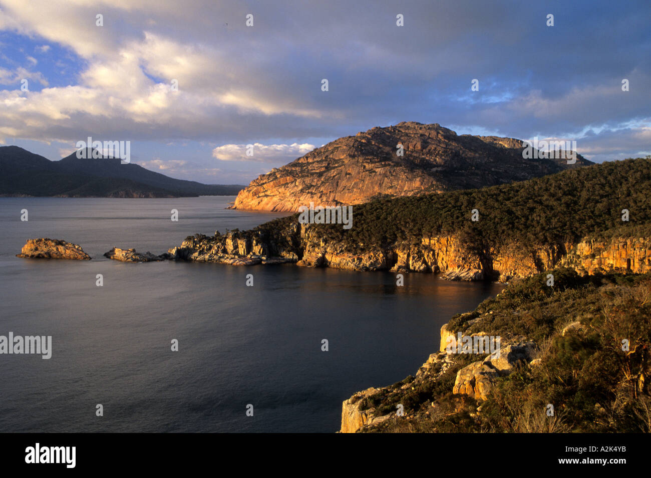 Australia e Tasmania, Parco Nazionale di Freycinet. Penisola rocciosa e barca dal faro. Foto Stock