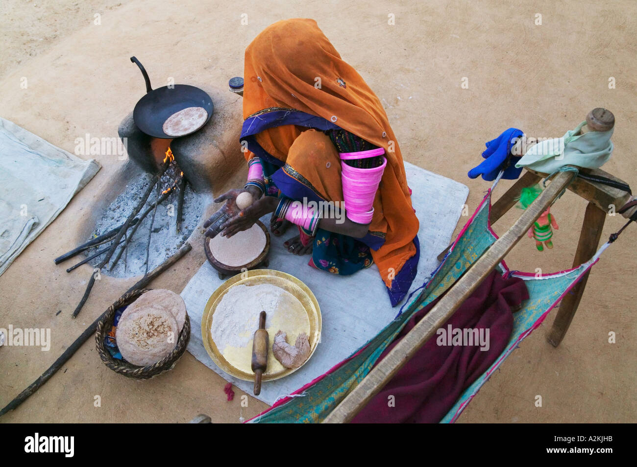Donna indiana rendendo japati nel cortile del Rajasthan in India Foto Stock