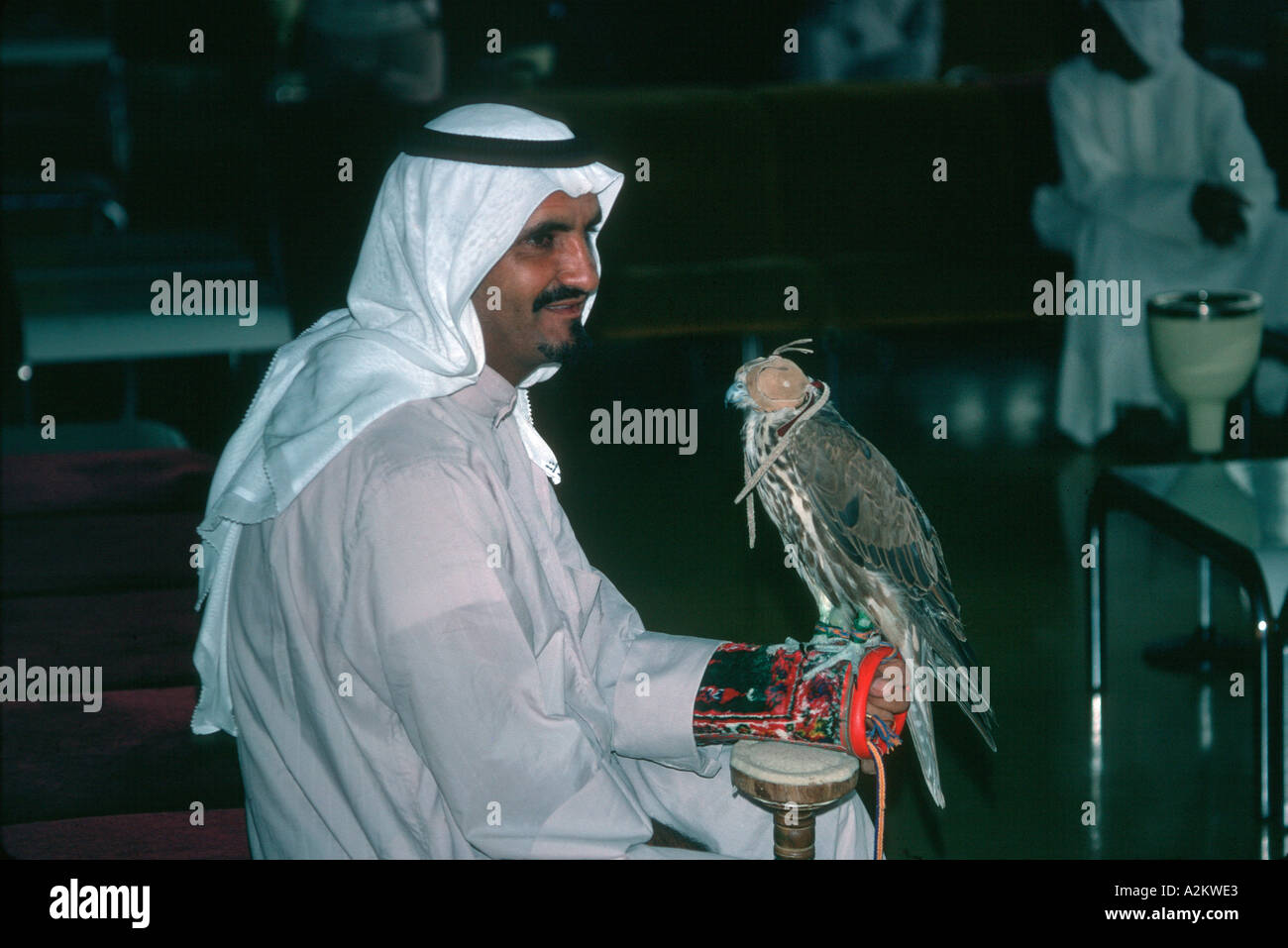 Arab falconer con hooded falcon aeroporto Bahrain Medio Oriente Foto Stock