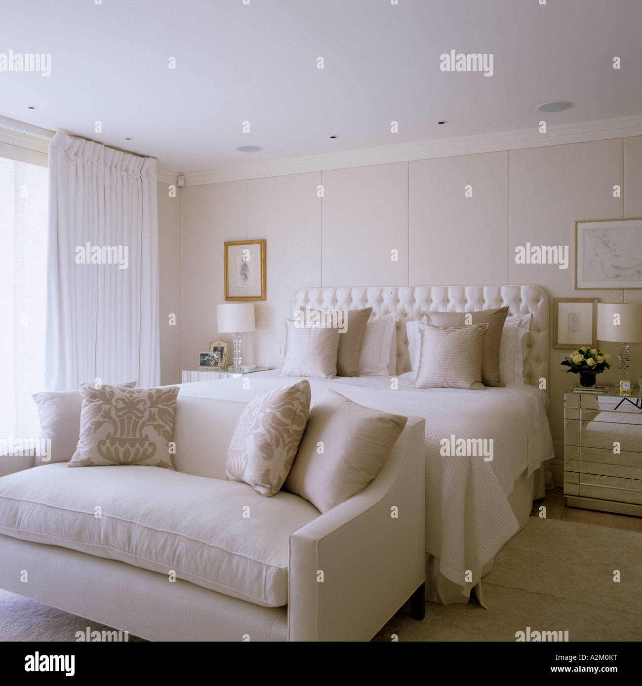 Eleganti camere da letto in crema con testiera imbottita e divano Foto Stock