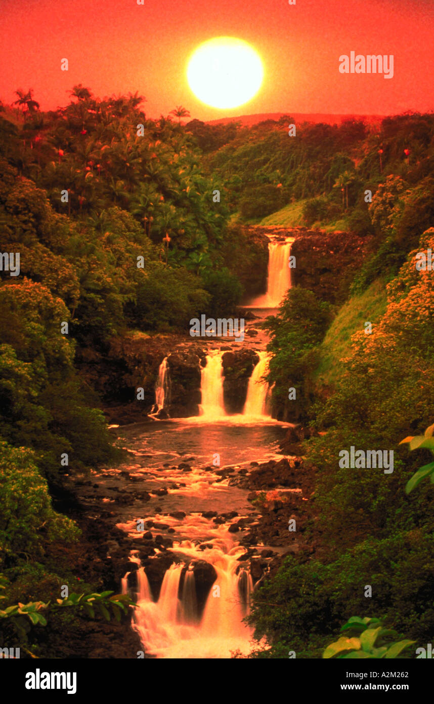 Una luce arancione brillante è appeso sopra Umauma Falls Big Island delle Hawaii Foto Stock