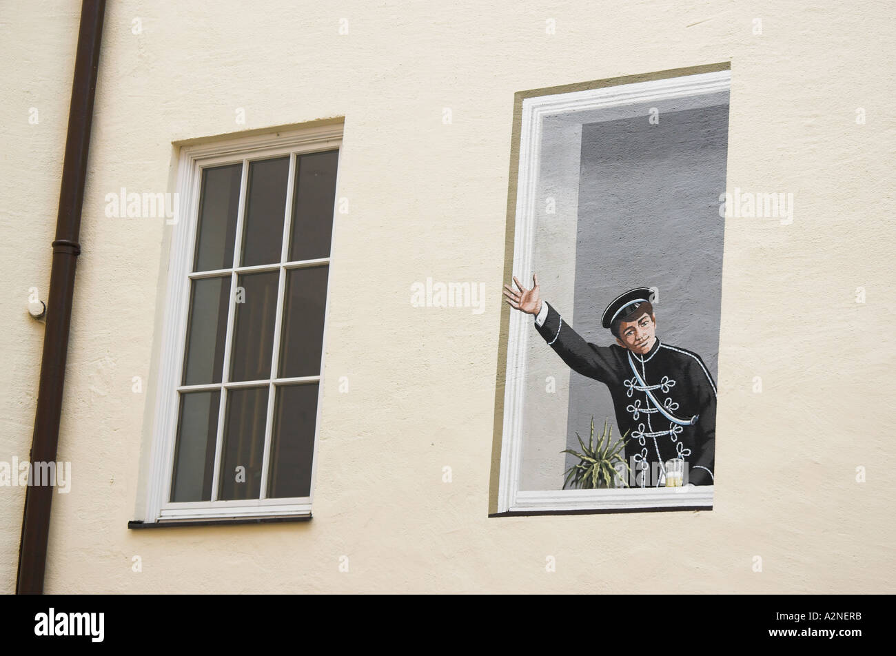 Finta finestra con una ondulazione uomo dipinta su un muro di casa a Monaco di Baviera, Germania Foto Stock