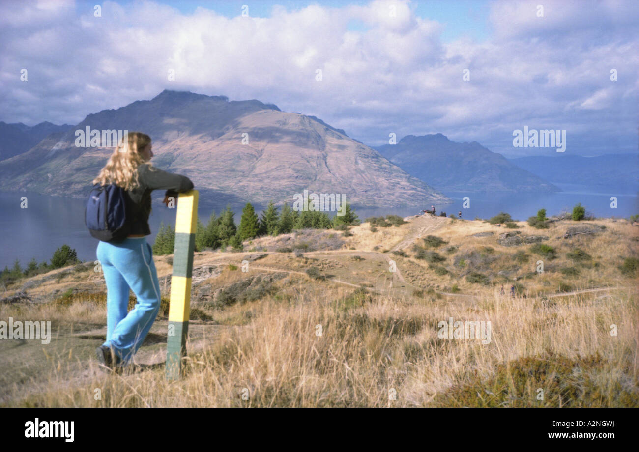 Walker ammirando la vista del mountians che circondano Queenstown e il lago Wakatipu, Isola del Sud, Nuova Zelanda Foto Stock