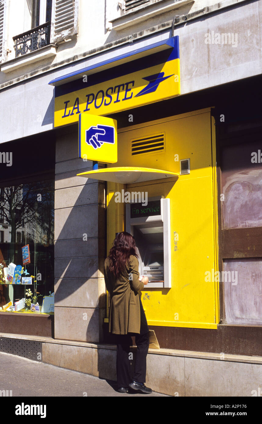 Donna che utilizza una macchina ATM all'ufficio postale francese Foto Stock
