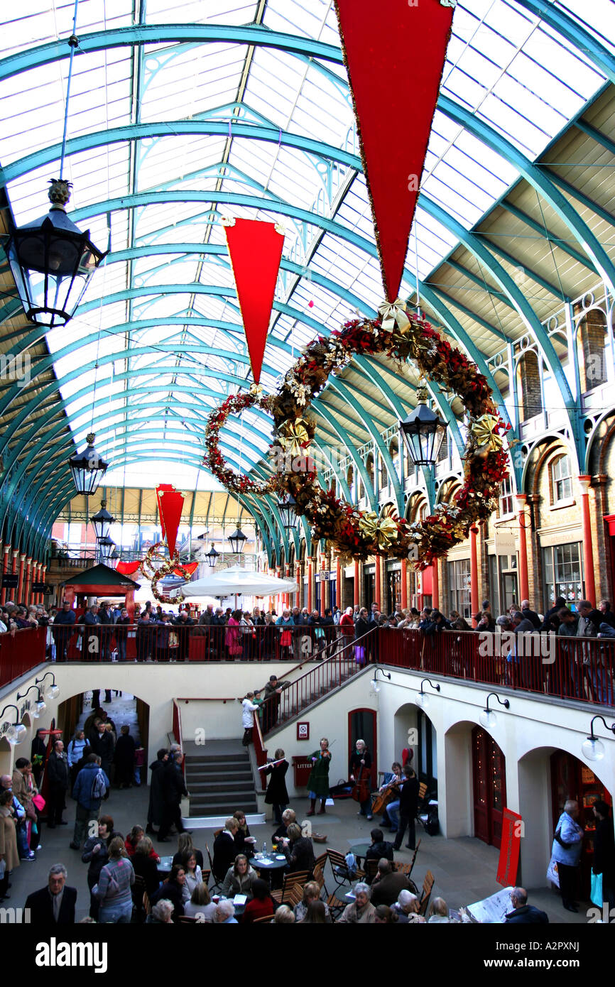 Un formato ritratto immagine di Covent Garden Il mercato coperto, Londra con persone intorno di fresatura. Foto Stock