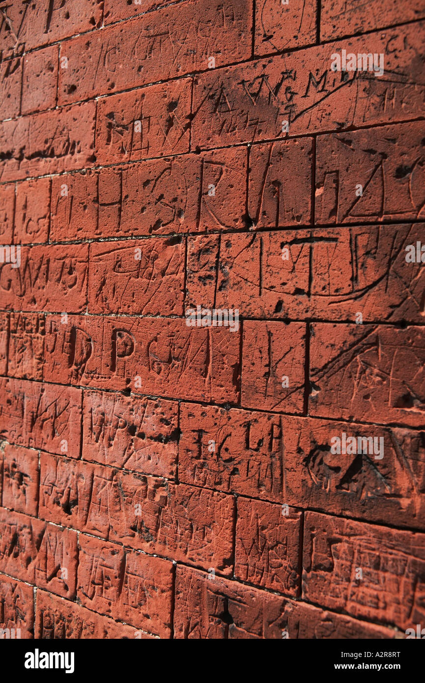Graffiti ha voluto in cotto sulle vecchie mura scolastiche Dedham North Essex REGNO UNITO Foto Stock
