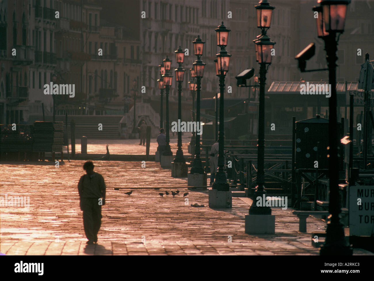 Venezia Italia un uomo cammina da solo all'alba lungo il bordo del Grand Canal Foto Stock