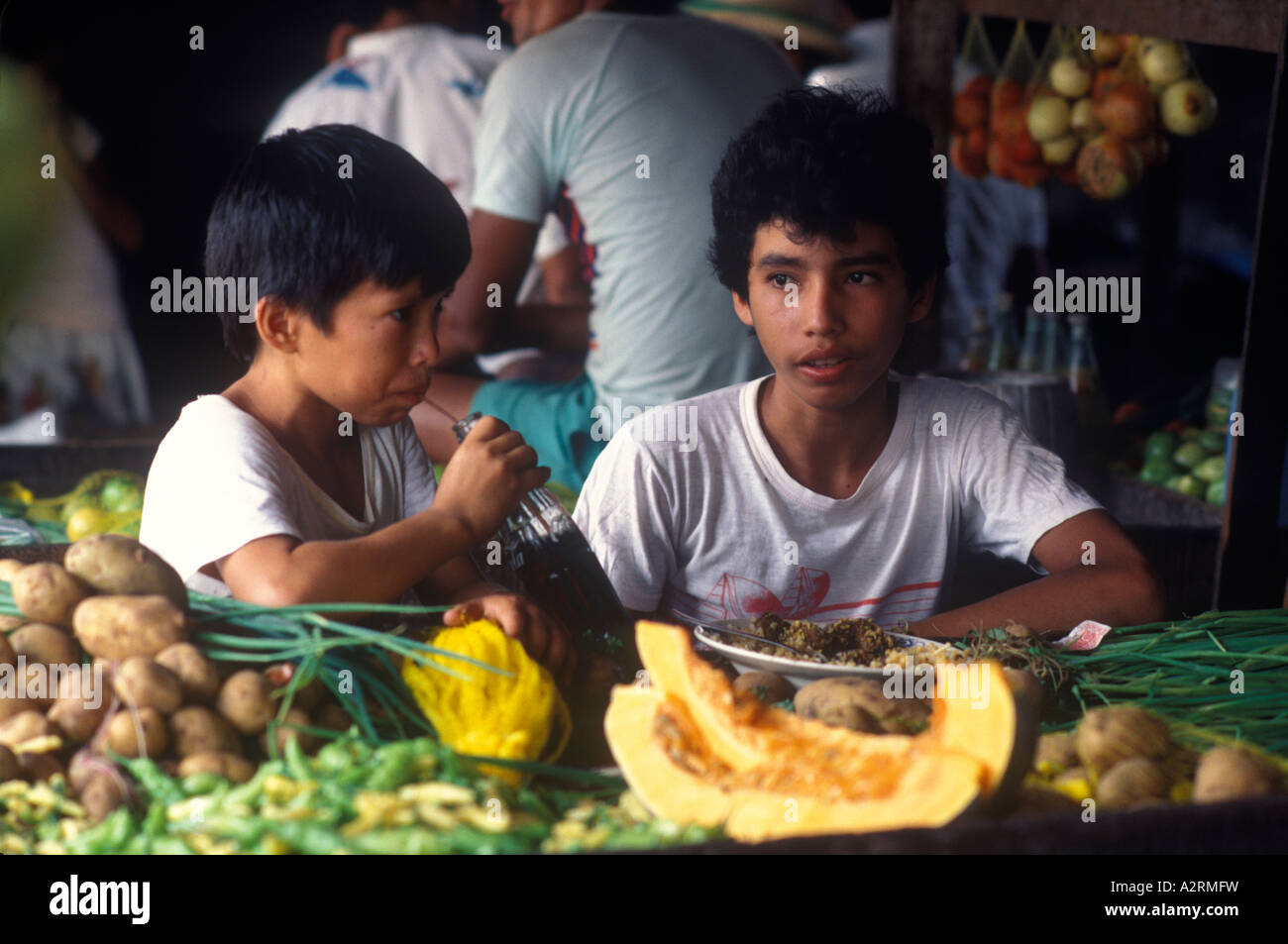 Manaus Brasile Sud America. I bambini mangiano in un bar del mercato di strada bevendo con una cannuccia di carta e una bottiglia di coca. 1980s 1985 HOMER SYKES Foto Stock