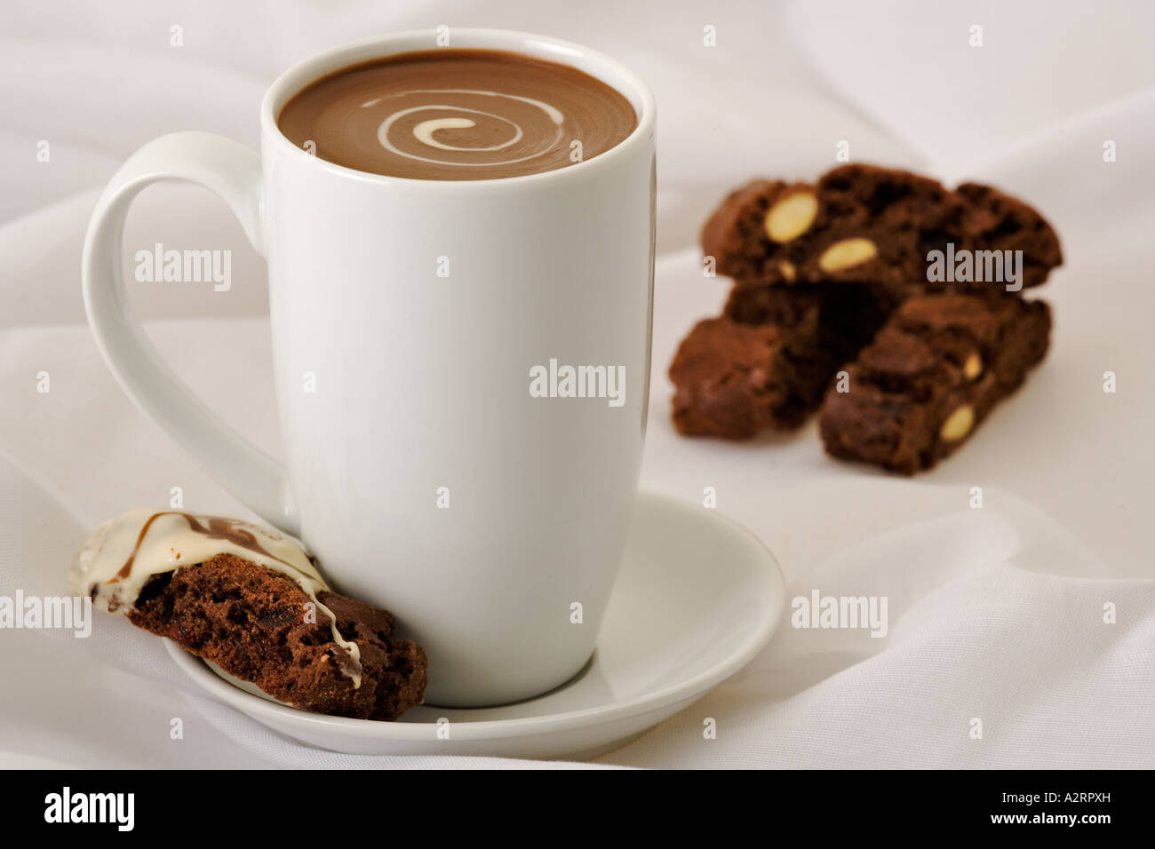 In porcellana bianca cup con la bevanda al cioccolato mandorle e cioccolato biscoti in background Studio shot Foto Stock