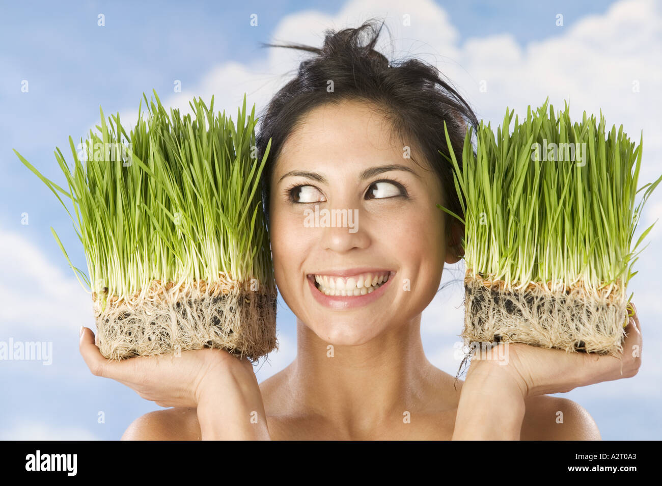 Donna che mantiene pentole di erba di frumento Foto Stock