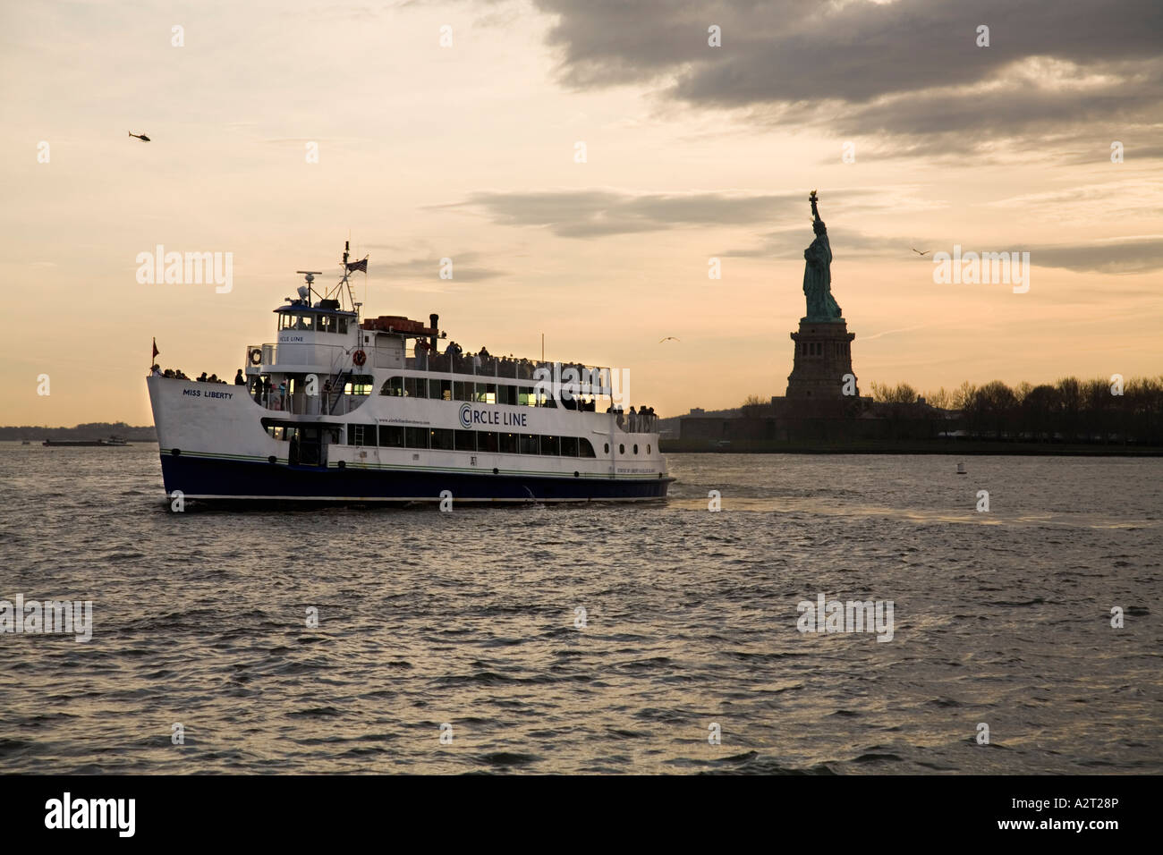 Circle line il traghetto e la Statua della Libertà al tramonto. New York STATI UNITI D'AMERICA Foto Stock