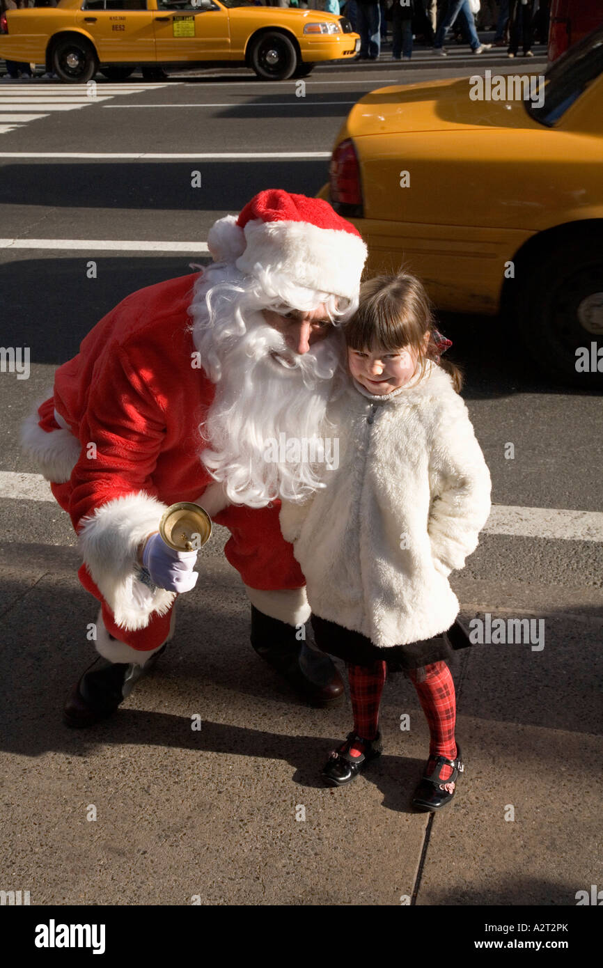 Ragazza incontra Babbo Natale vicino al Rockefeller Center e Saks Fifth Avenue di New York City STATI UNITI D'AMERICA Foto Stock