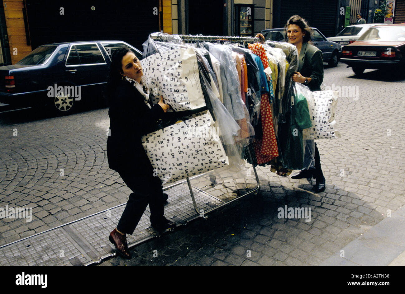 Donne wheeling rack di vestiti street napoli Italia 1993 Foto Stock