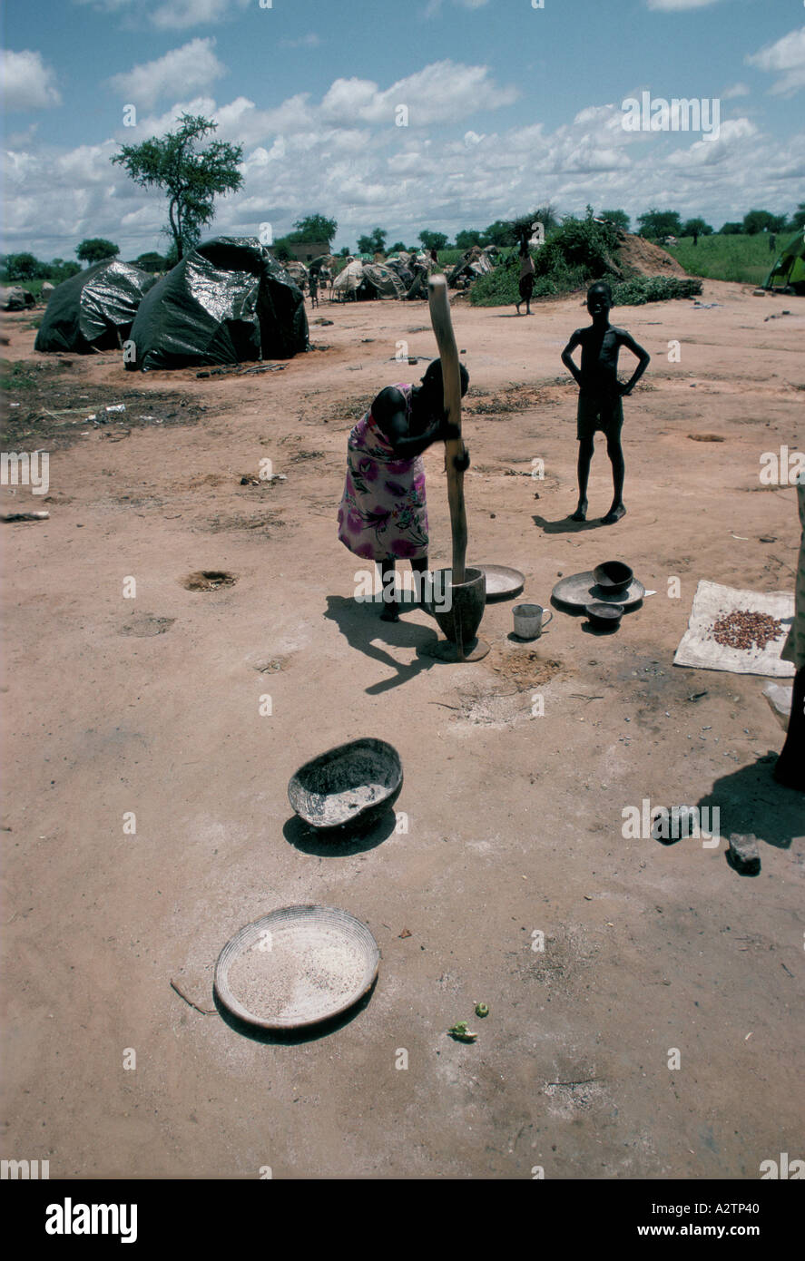 Donna pounding con pestello e morter el muglad carestia camp sudan 1988 1988 Foto Stock