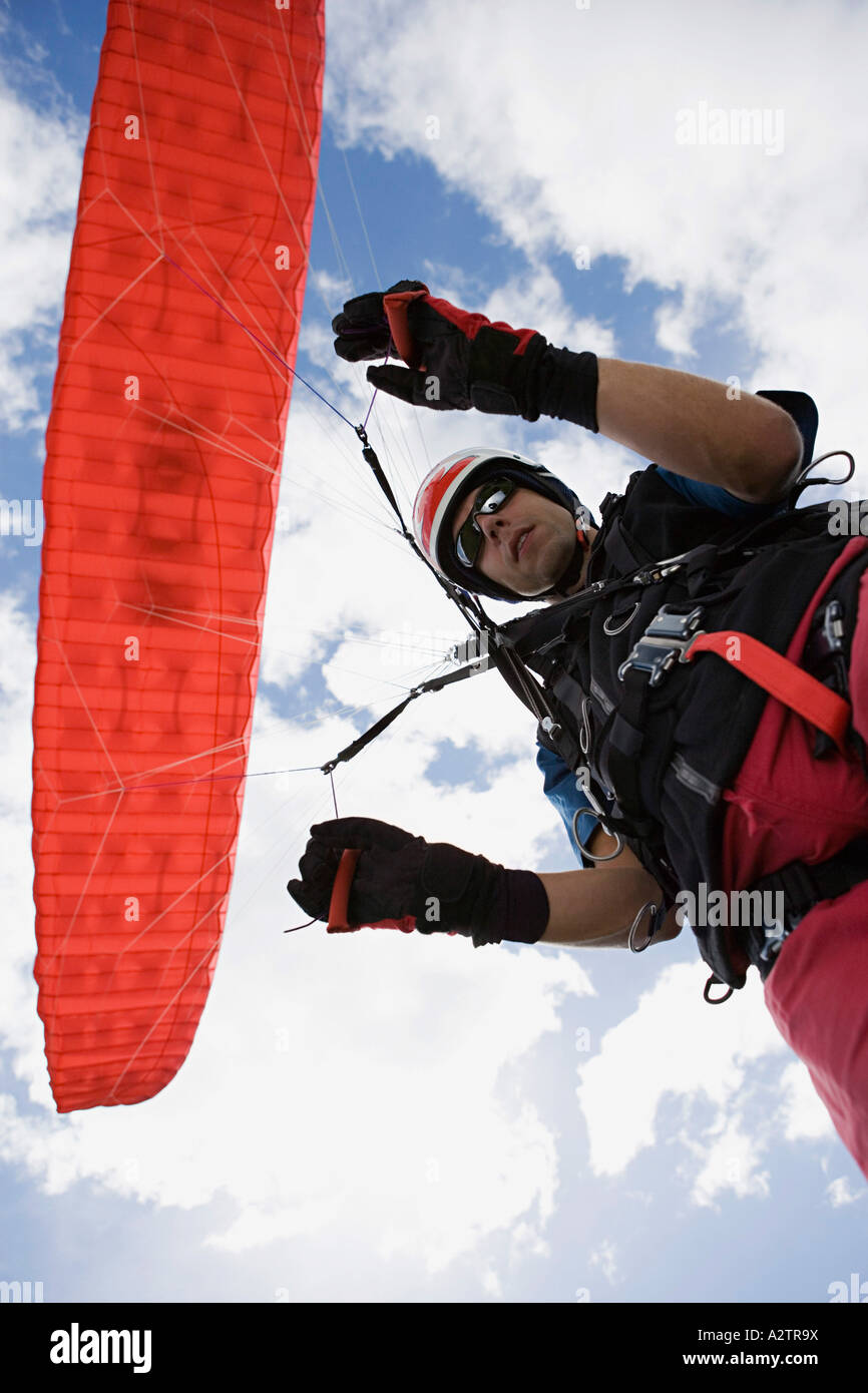 Parachutist maschio con paracadute rosso Foto Stock