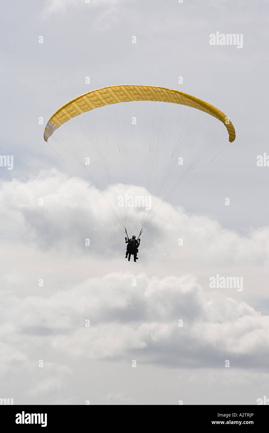 Persona con un paracadute di colore giallo Foto Stock