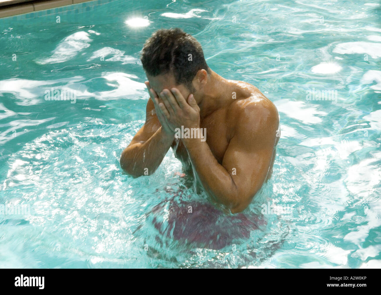 Uomo in piscina faccia di tergitura Foto Stock