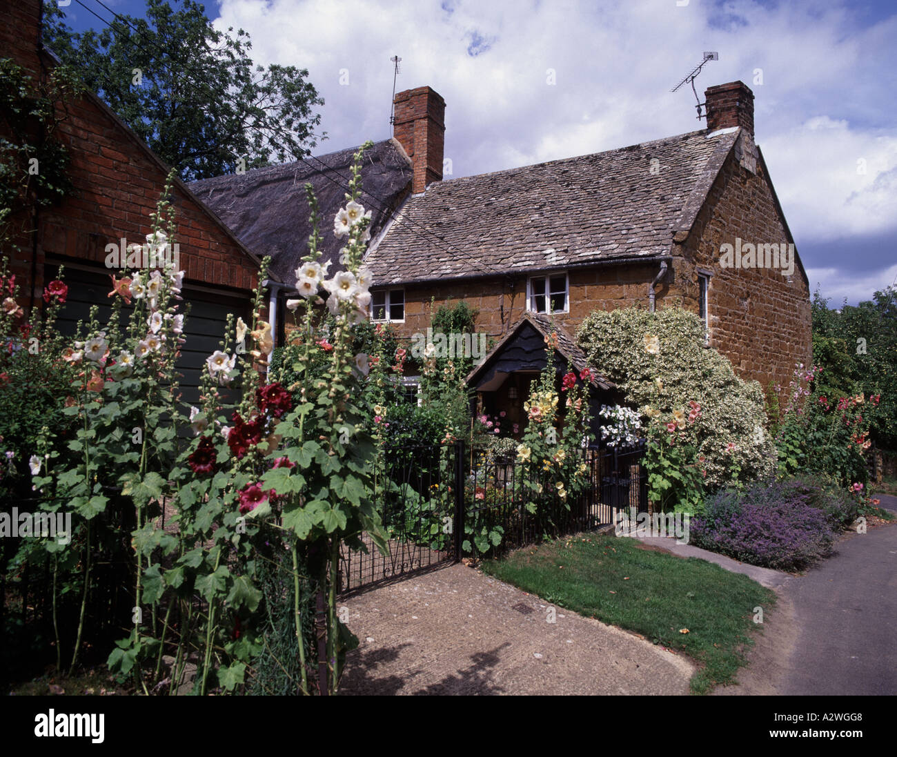 Un molto inglese cottage di campagna con i fiori intorno alla sua porta, nel villaggio di Ilmington Foto Stock