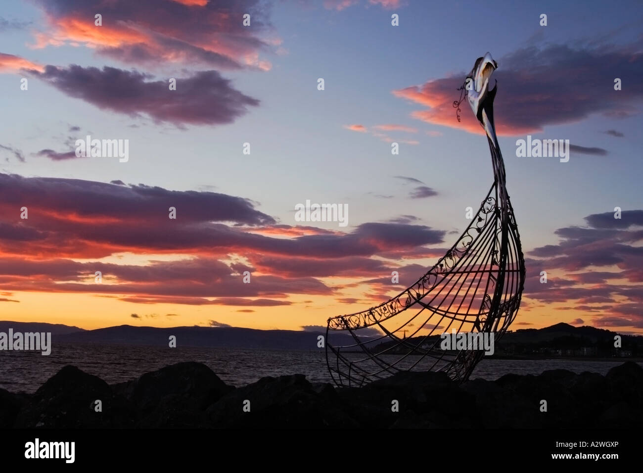 Il post-incandescenza del tramonto dietro il Viking longboat scultura a Largs marina Foto Stock