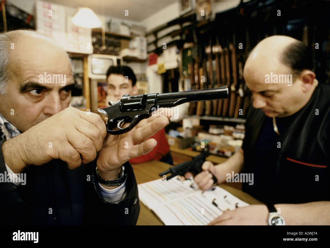 Un uomo esamina attentamente una smith e Wesson magnum 44 Foto Stock