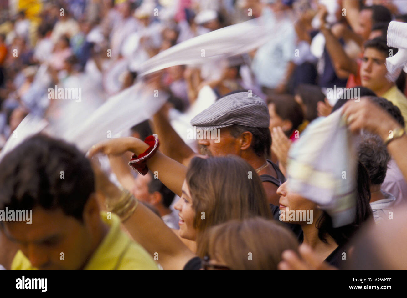Una ragazza e uomo in un tappo piatto stand in mezzo alla folla alla corrida  le persone sono sventolando fazzoletti bianchi huelva Foto stock - Alamy