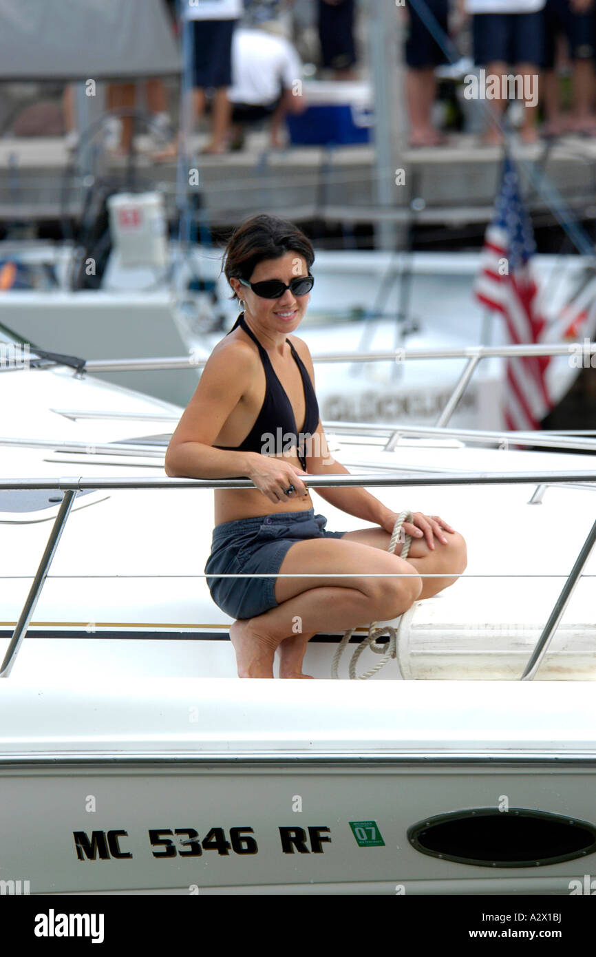 Femmina adulta su una barca di indossare hotpants bikini top e occhiali da sole. Foto Stock