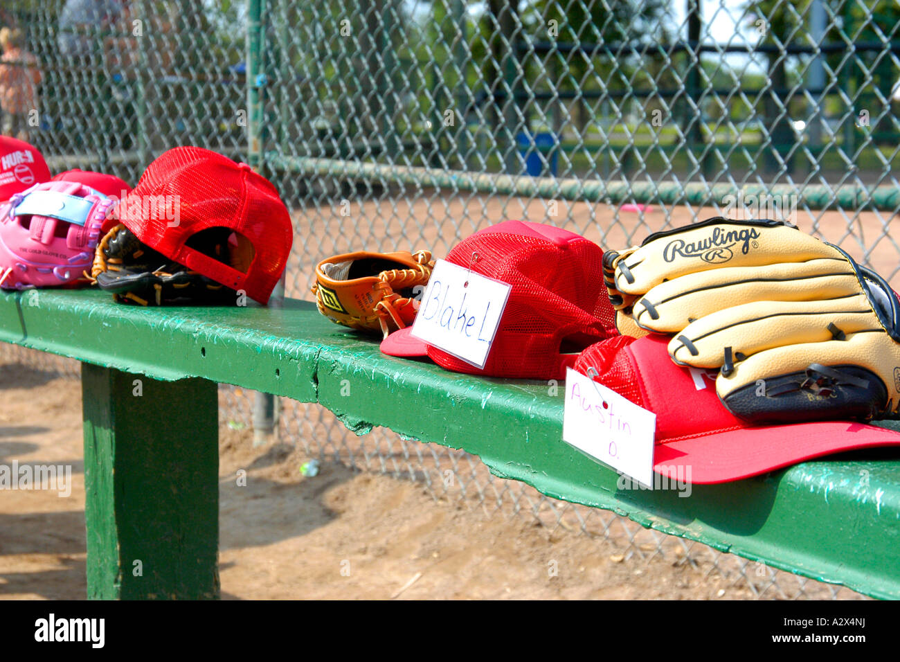 Caschi, guanti e berretti da baseball tutti seduti su una panchina stadium. Foto Stock